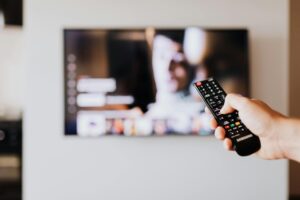 person using remote control to navigate smart tv streaming content